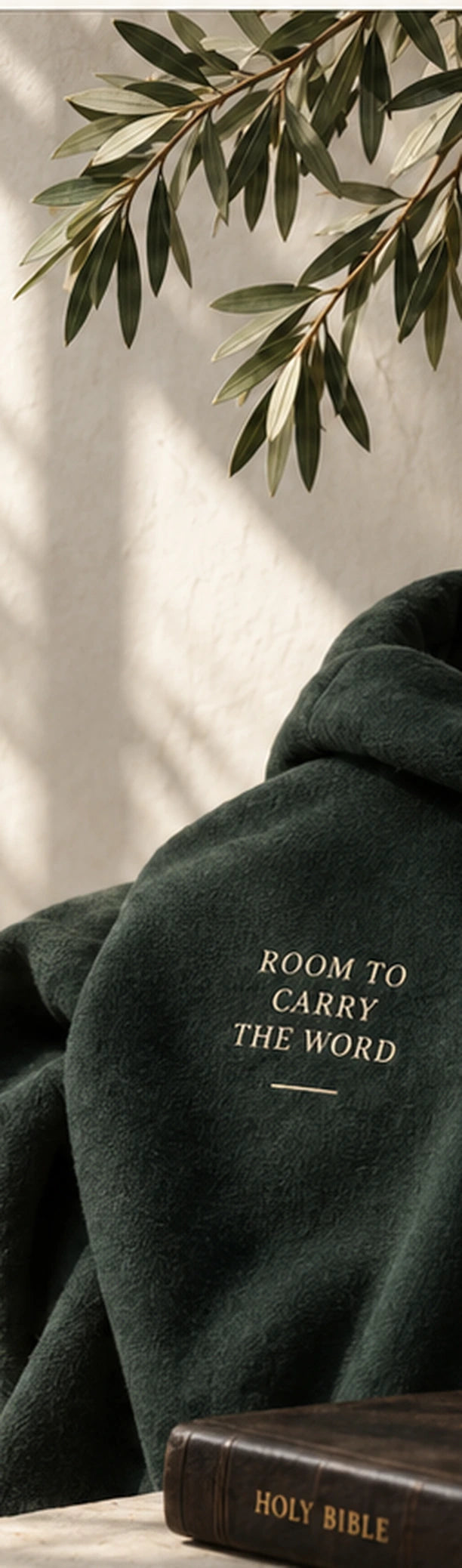 Forest green VERSE garment beside a Holy Bible with the words Room to Carry the Word.